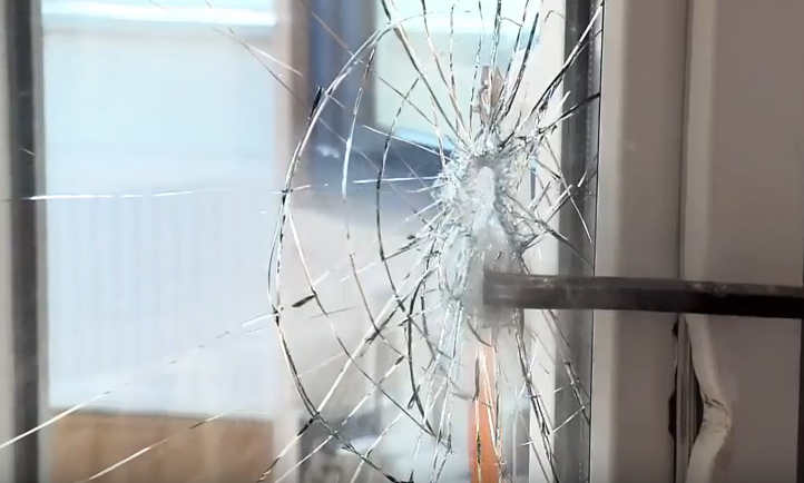 einbrecher öffnet ein fenster mit brecheisen